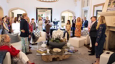 Guests gathered in a refined living room setting at a Palm Beach charity preview event