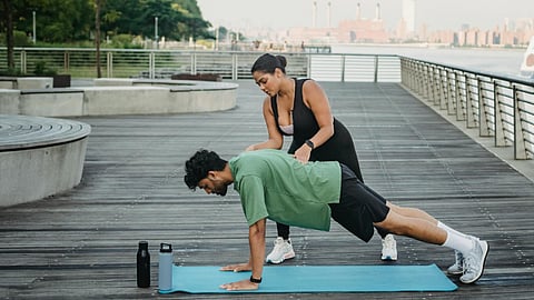 Trainer guiding mobility and strength work during an outdoor fitness session