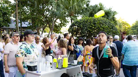 A bartender flips a shaker at the Las Olas Food and Wine Festival in Fort Lauderdale