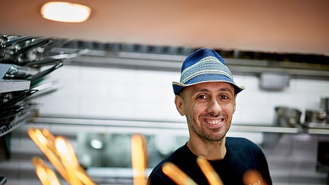 Chef Philip Guardione smiling inside Piccola Cucina kitchen in New York City