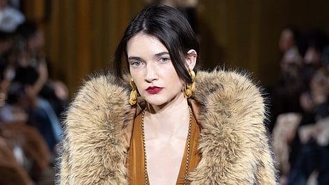 Model walks in a deep ochre gown and oversized faux fur stole at Cinq à Sept FW26 NYFW runway
