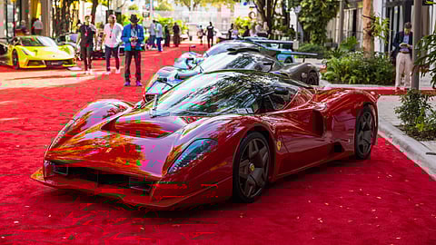 Red Ferrari P4/5 displayed on red carpet with hypercars and guests in Miami