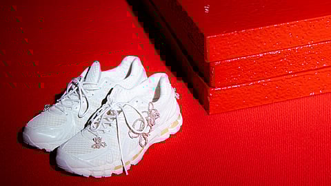 White and black ASICS GEL-KAYANO 20 sneakers with sculptural jewellery details on a red set