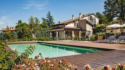 Restored Italian countryside villa with stone façade and private pool surrounded by gardens