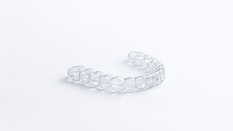 Transparent dental aligner tray designed to straighten teeth for adults