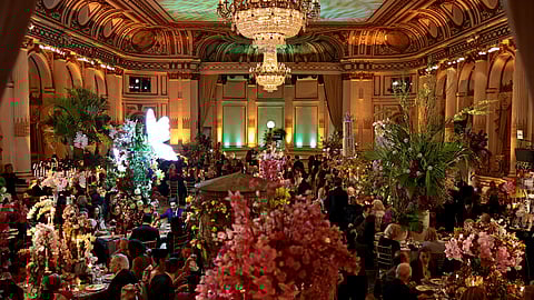Guests dine beneath crystal chandeliers surrounded by dramatic floral installations at The Plaza