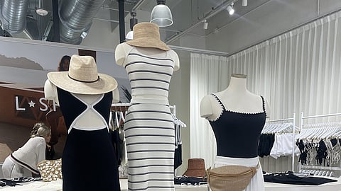 Display of neutral resort looks with straw hats and woven tote inside LSPACE pop-up