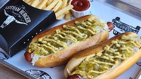 Hot dogs topped with sauerkraut, relish, and mustard served with fries at Gotham Burger Social Club