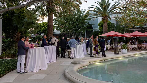 Palm Beach outdoor event with guests socializing beside a pool at sunset