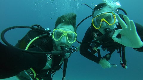 Two scuba divers underwater giving OK signal during ocean dive