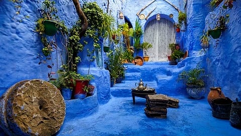 Blue-painted courtyard with plants and traditional decor in Moroccan village