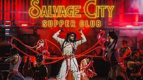 Performers in red lighting dance with ropes on stage beneath Salvage City Supper Club sign