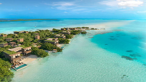 Aerial view of Emerald Caye with overwater villas and turquoise sea