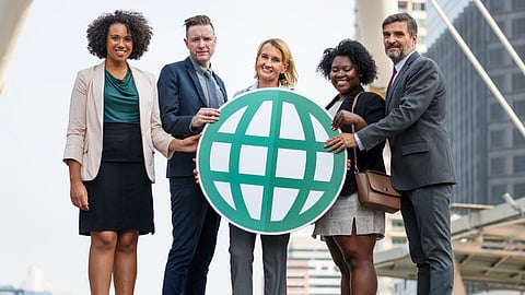 Group of professionals holding globe icon outdoors