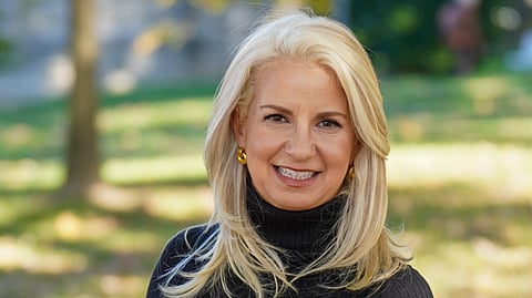 Portrait of Mary V. Slinkard seated outdoors wearing a black turtleneck