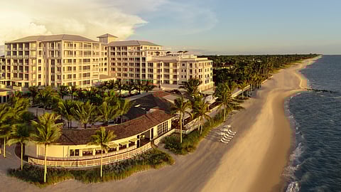 Aerial view of Naples Beach Club resort and palm-lined Gulf Coast shoreline