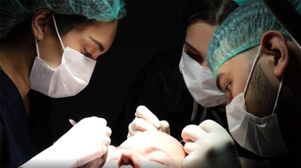 Medical team performing a hair transplant procedure with surgical precision
