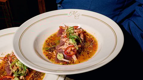 Plated seafood dish with chili and citrus sauce at an exclusive dinner