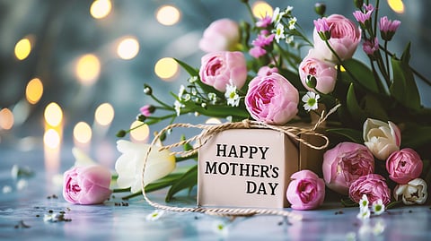 Pink spring flowers surround a gift box with a Mother’s Day message.
