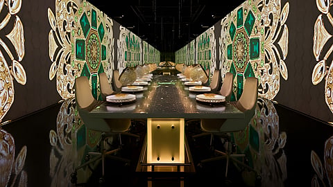 Futuristic dining room with long table and digital projections covering walls