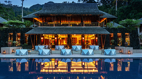 Open-air restaurant at The Datai Langkawi with poolside tables at dusk
