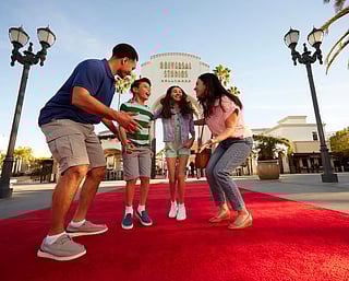 Family walking red carpet at Universal Studios Hollywood entrance Los Angeles