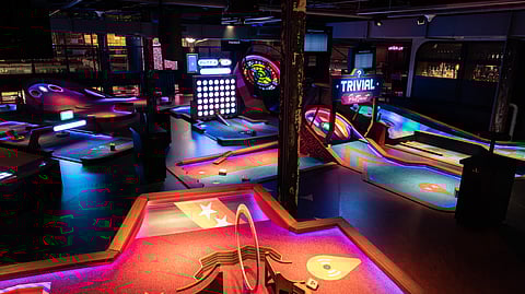 Indoor mini golf venue with colorful neon courses and interactive game features
