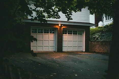 A two-car garage attached to a residential home at night.