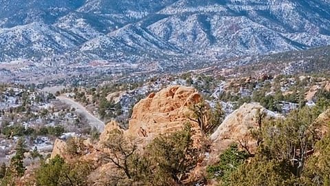 A scenic view of the Garden of the Gods park with Pikes Peak in the background. 