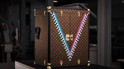 Louis Vuitton trophy trunk with monogram and colorful V stripes in workshop setting