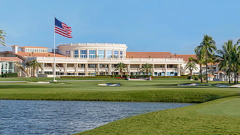 Trump National Doral clubhouse overlooking golf course and water with American flag