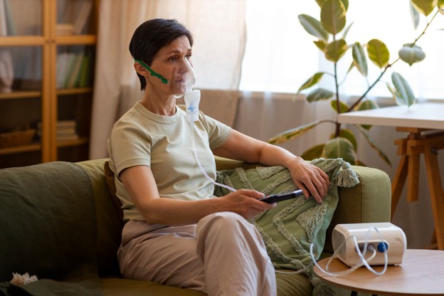 A person using a medical nebulizer to administer medication