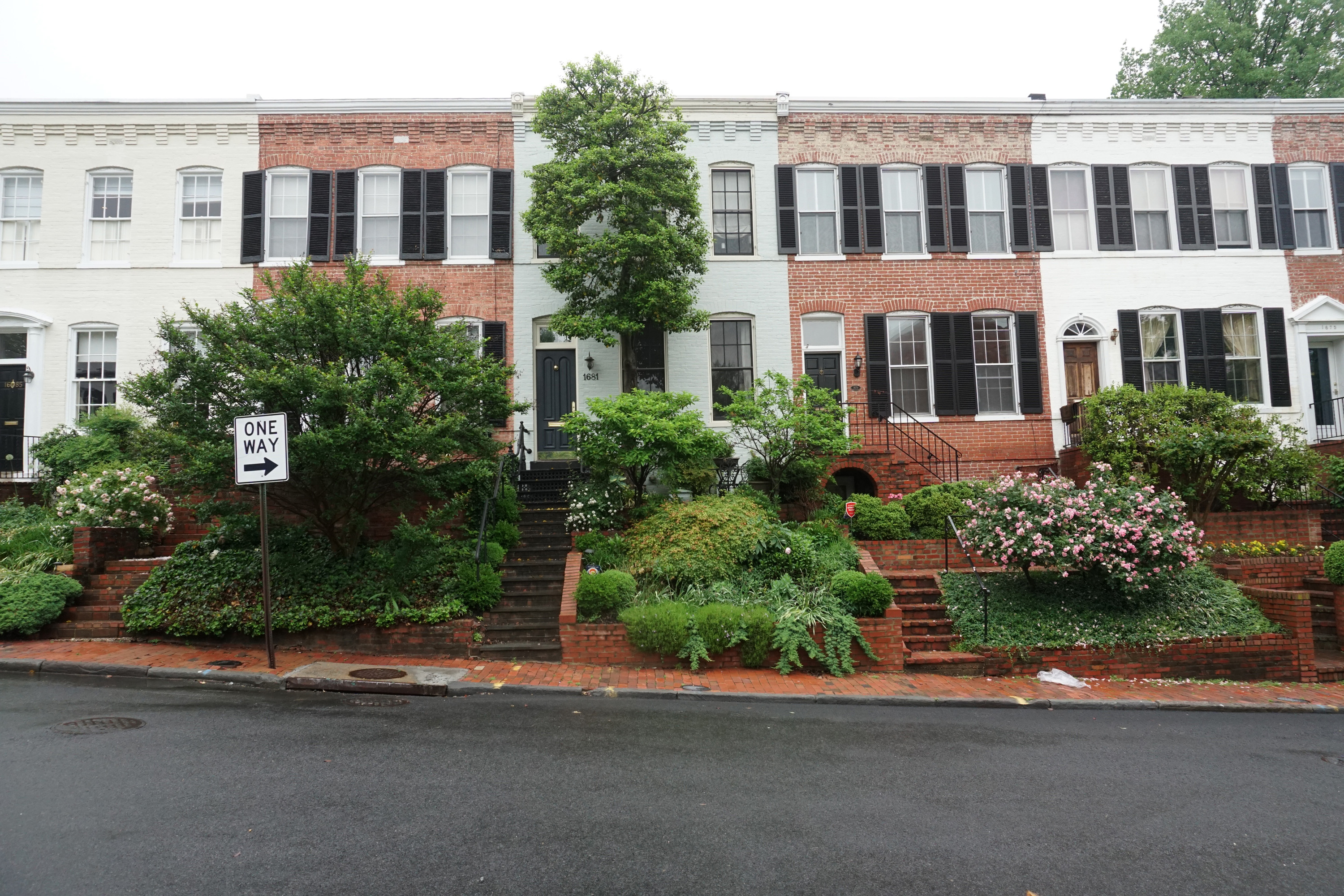 Row of townhouses on a quiet residential street with greenery and sidewalks