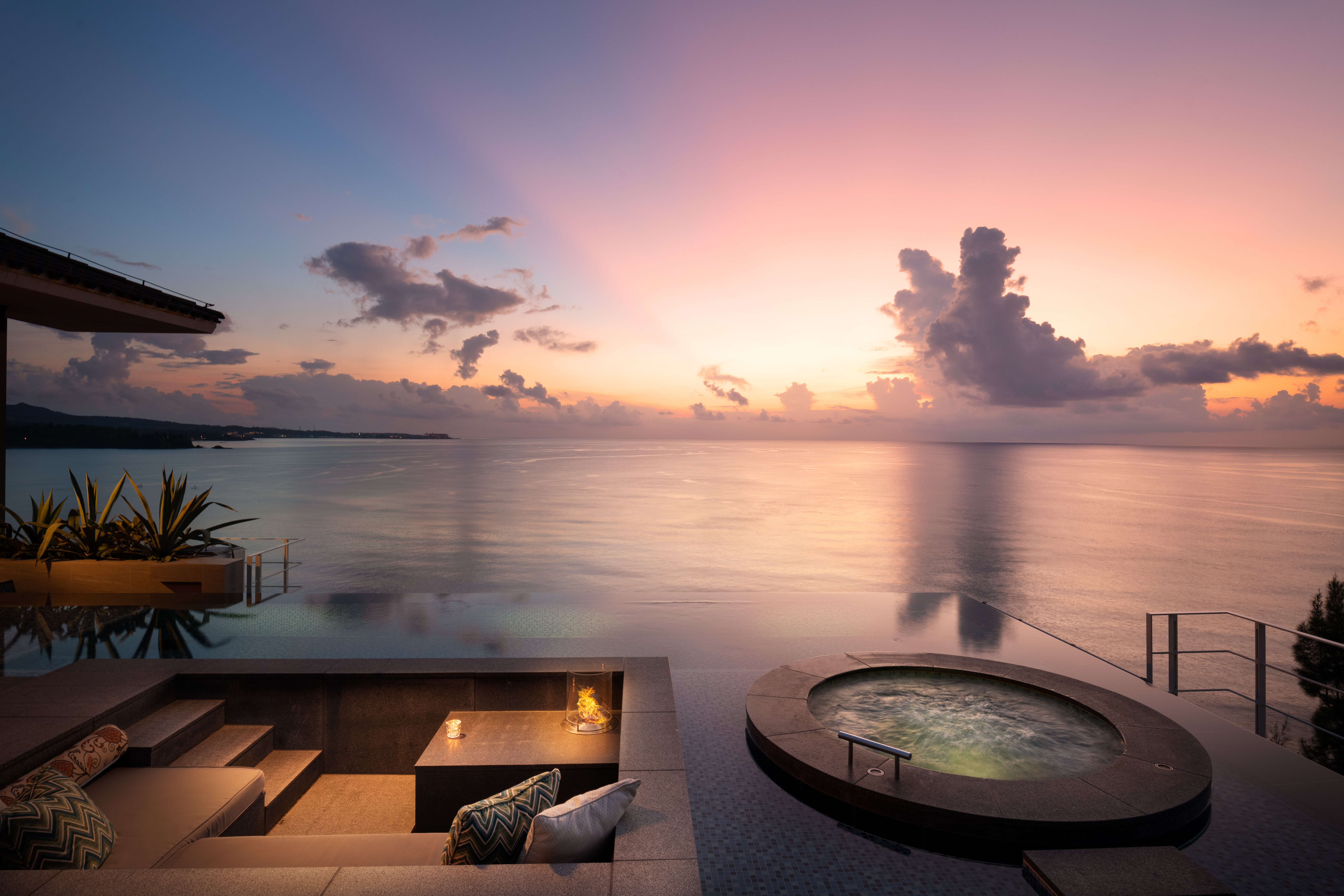 Private terrace with infinity pool and hot tub overlooking ocean at sunset