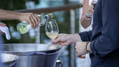 Guests sipping wine at a waterfront Federdoc event in Miami with Biscayne Bay views