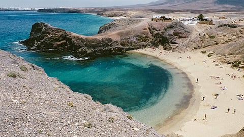 High-angle view of Papagayo Beach in Lanzarote with turquoise water and volcanic cliffs