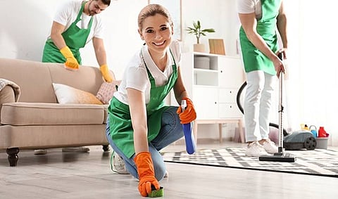 professional cleaners working together to tidy a living room