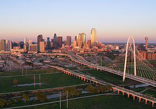 Dallas, Margaret Hunt Hill Bridge on the right and the downtown Dallas skyline at sunset