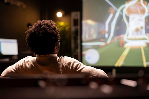 an African American gamer focused on a large screen