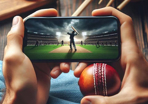 a person holding a smartphone displaying a live cricket match
