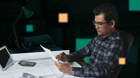 Construction estimator reviewing project plans with blueprints and calculator