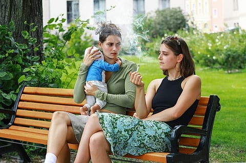 two women sitting on a park bench