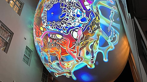 Colorful abstract projection artwork illuminates The Betsy Orb above Espanola Way in Miami Beach