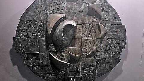 Abstract circular wall sculpture with layered geometric textures and curved forms