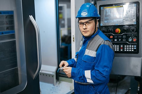 an industrial worker operating a CNC machine