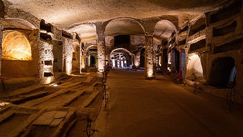 Illuminated stone corridors and burial chambers inside a historic Italian catacomb