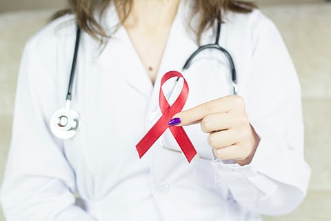 a doctor holding a red ribbon
