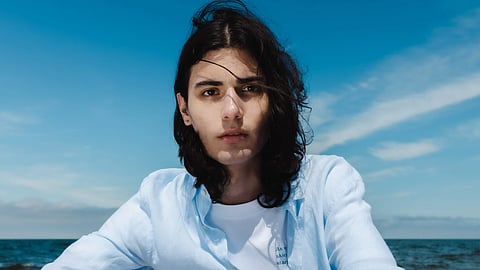 Model wears a light linen shirt and resort wear from BEIGE | BROWN by the sea