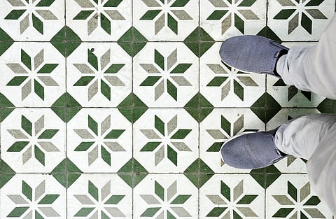 a person sitting on a tile floor