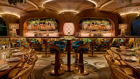 Amazónico Miami bar with woven seating, tropical décor, and warm lighting